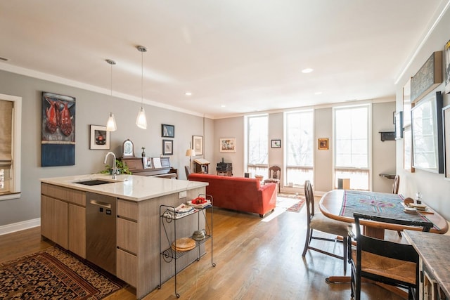 kitchen featuring a kitchen island with sink, a sink, open floor plan, stainless steel dishwasher, and modern cabinets