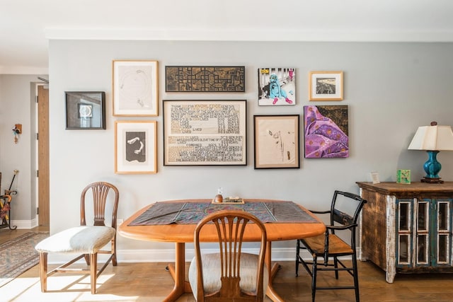 dining space featuring baseboards, breakfast area, and wood finished floors