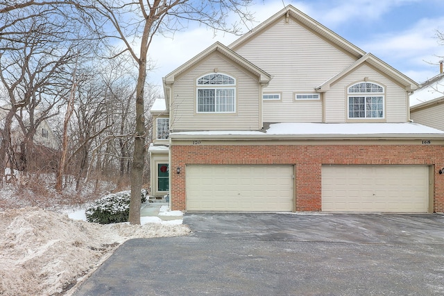 view of front of house with brick siding, driveway, and an attached garage