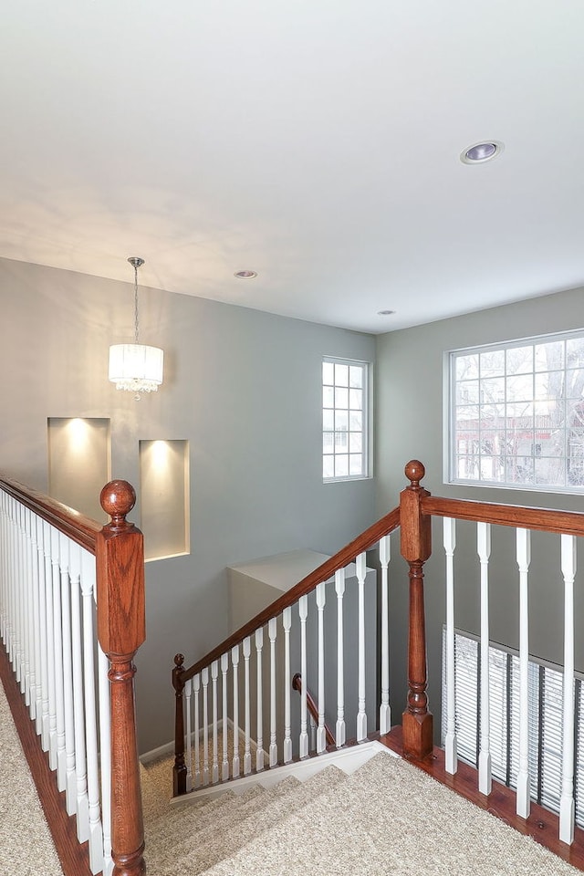 stairway featuring a notable chandelier