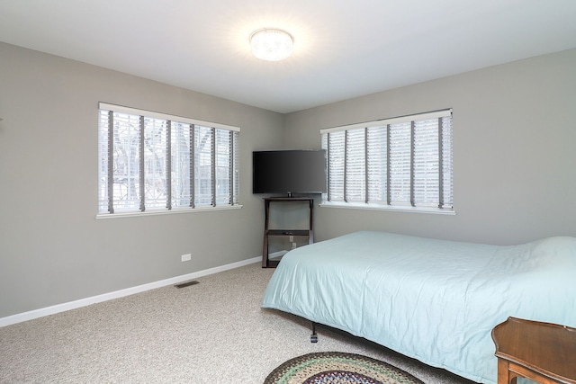 bedroom featuring visible vents, multiple windows, baseboards, and carpet flooring