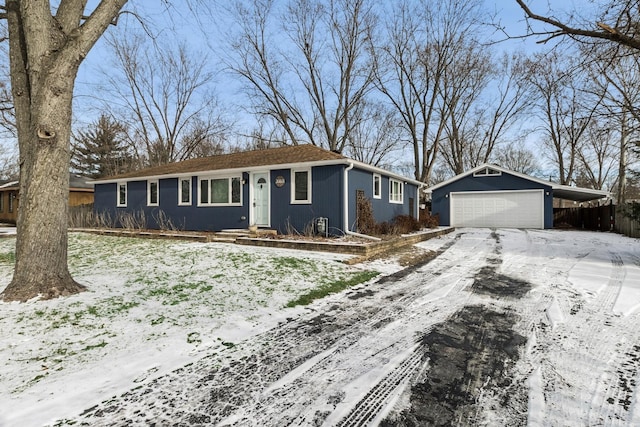 ranch-style home featuring a detached garage and an outbuilding