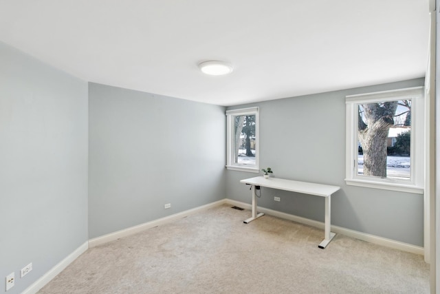 home office featuring light carpet, a healthy amount of sunlight, and baseboards