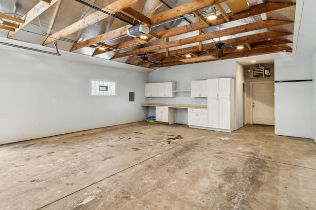 garage with electric panel, a ceiling fan, and a garage door opener