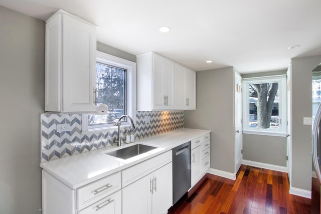 kitchen with a sink, white cabinetry, light countertops, stainless steel dishwasher, and backsplash