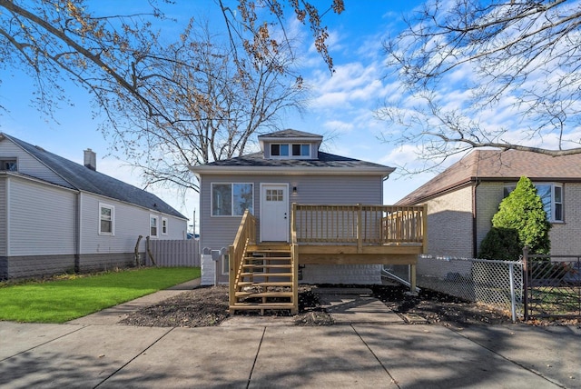 view of front facade with stairway, a front yard, fence, and a deck