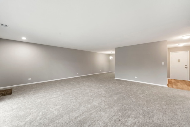 spare room featuring carpet flooring, visible vents, and baseboards