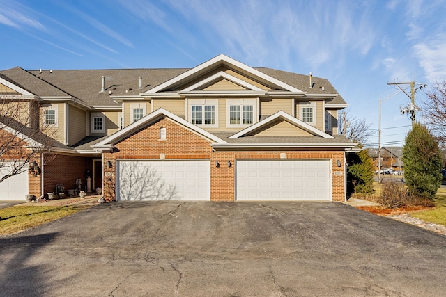 view of front of property featuring a garage, driveway, and brick siding