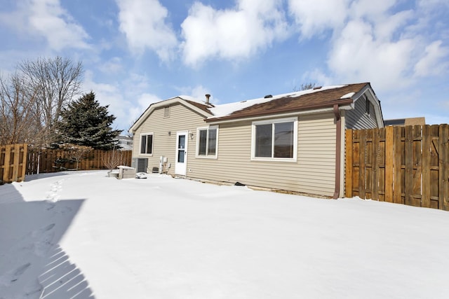 snow covered rear of property featuring fence