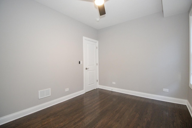 empty room featuring visible vents, dark wood finished floors, baseboards, and ceiling fan