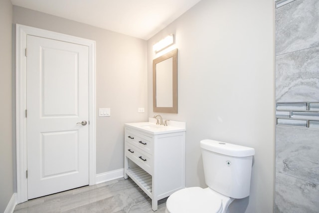 bathroom featuring marble finish floor, baseboards, vanity, and toilet