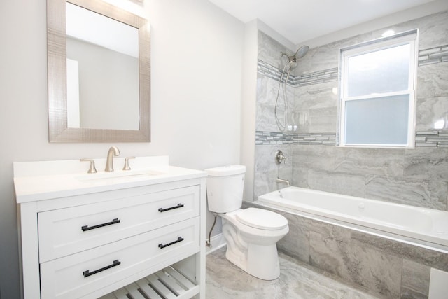 bathroom featuring toilet, tiled shower / bath, and vanity