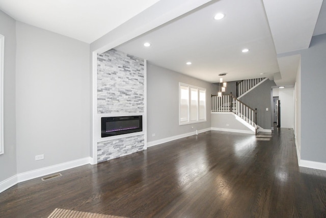 unfurnished living room with recessed lighting, a large fireplace, dark wood-style flooring, baseboards, and stairs