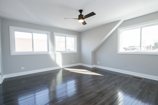 bonus room featuring a ceiling fan, baseboards, visible vents, and dark wood-style flooring