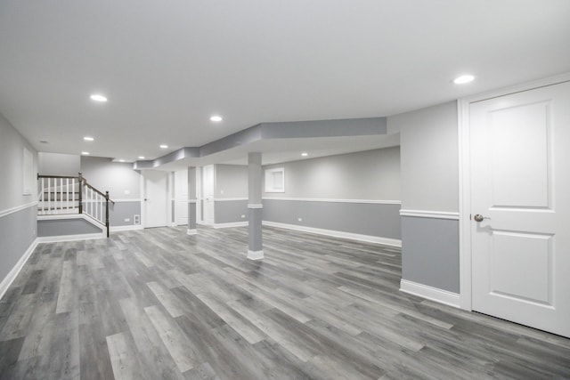 finished basement with recessed lighting, wood finished floors, baseboards, and stairs