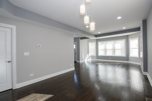 unfurnished living room featuring baseboards, dark wood-type flooring, and recessed lighting