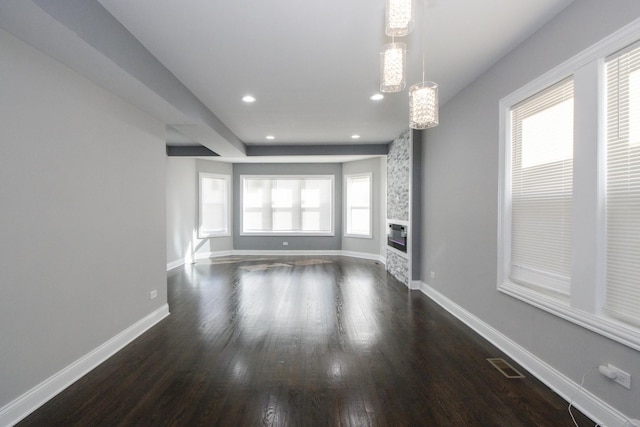 unfurnished living room featuring recessed lighting, dark wood-type flooring, a fireplace, visible vents, and baseboards