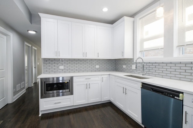 kitchen featuring a sink, stainless steel appliances, light countertops, and white cabinetry