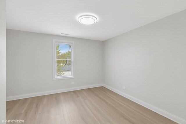 spare room with light wood finished floors and baseboards