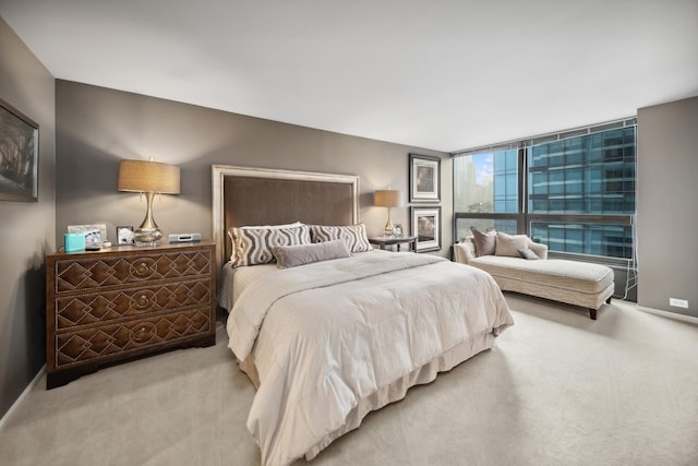 carpeted bedroom with expansive windows and baseboards