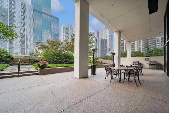 view of patio / terrace with a view of city, grilling area, and outdoor dining space