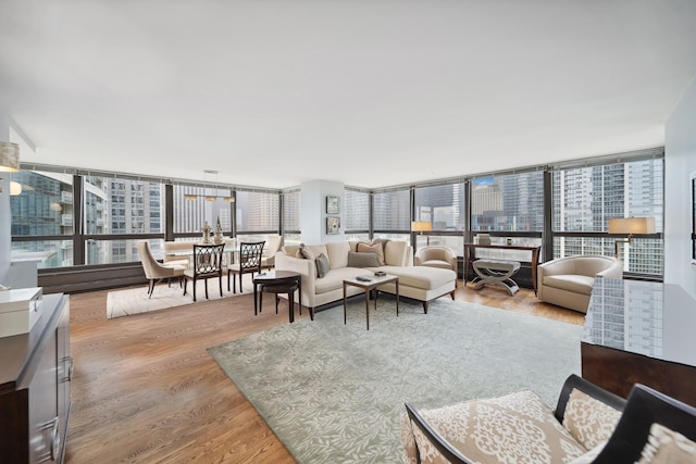 living room with light wood-style floors, a view of city, and expansive windows