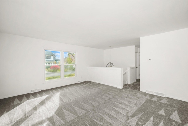 unfurnished room with baseboards, visible vents, and carpet flooring