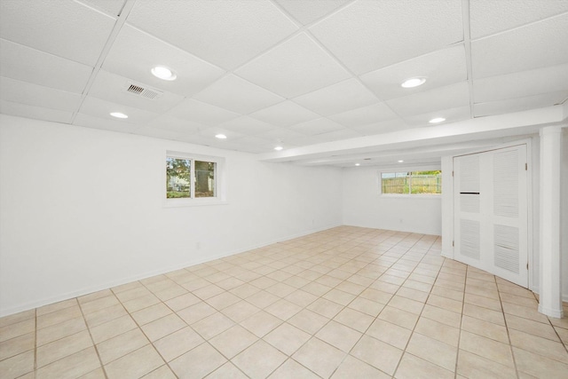 basement with a paneled ceiling, plenty of natural light, visible vents, and recessed lighting