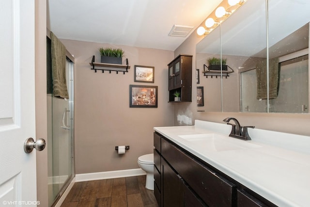 full bathroom with baseboards, wood finished floors, visible vents, and a shower stall