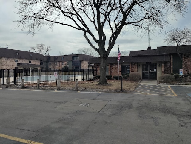 view of building exterior featuring uncovered parking and fence