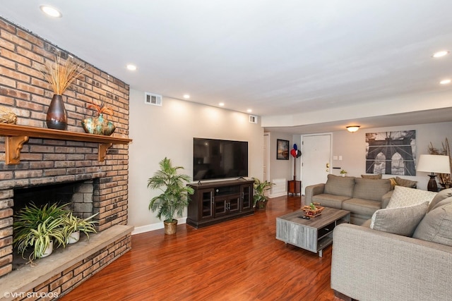 living room with recessed lighting, a fireplace, wood finished floors, visible vents, and baseboards