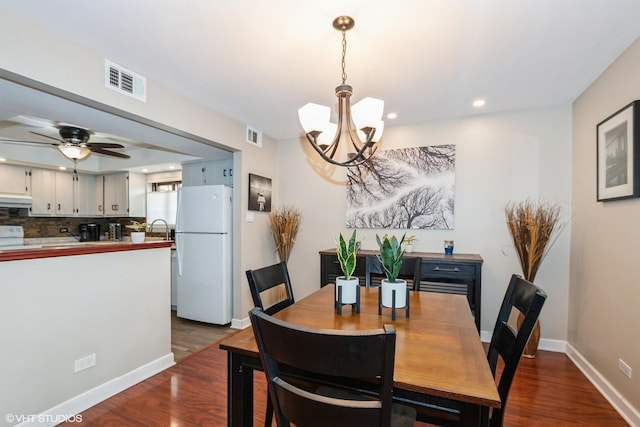 dining area featuring dark wood-style flooring, recessed lighting, visible vents, baseboards, and ceiling fan with notable chandelier