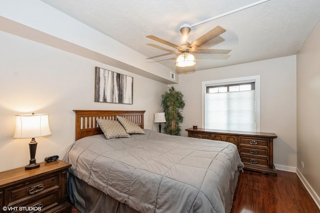 bedroom featuring dark wood-style flooring, visible vents, a ceiling fan, a textured ceiling, and baseboards