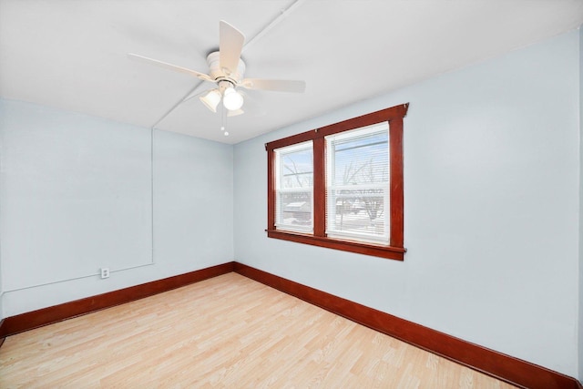 spare room with ceiling fan, light wood-type flooring, and baseboards