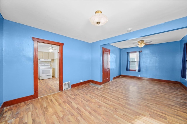 spare room with light wood-style floors, visible vents, ceiling fan, and baseboards