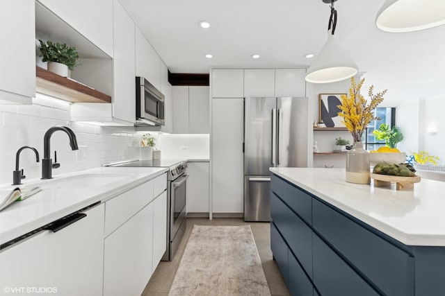 kitchen featuring appliances with stainless steel finishes, white cabinetry, and modern cabinets