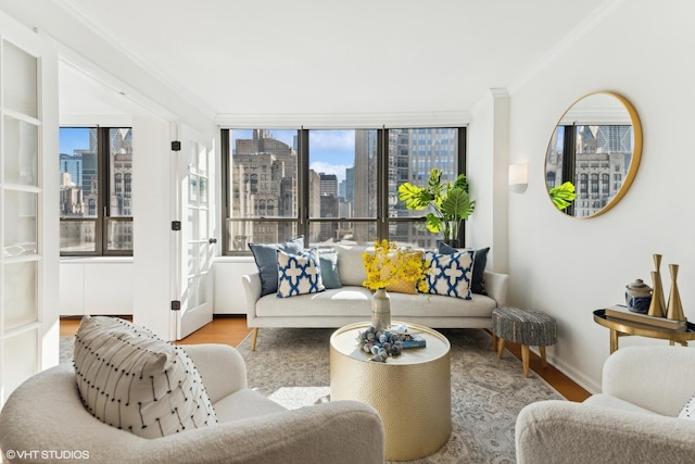 living room featuring ornamental molding, a wealth of natural light, a city view, and wood finished floors