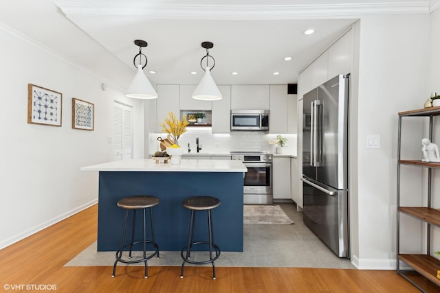 kitchen with decorative light fixtures, open shelves, stainless steel appliances, light countertops, and white cabinetry