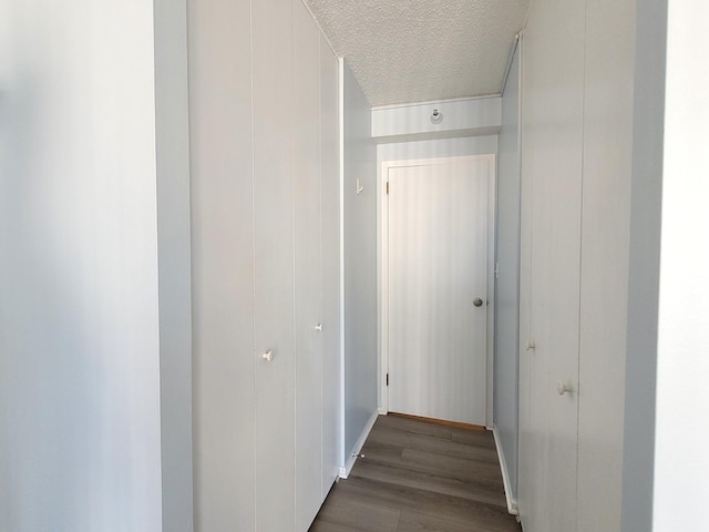 hallway featuring a textured ceiling and wood finished floors