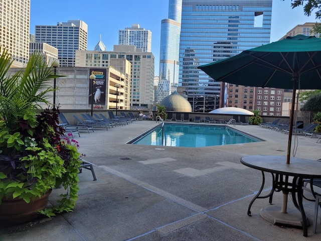 pool with a view of city and a patio area