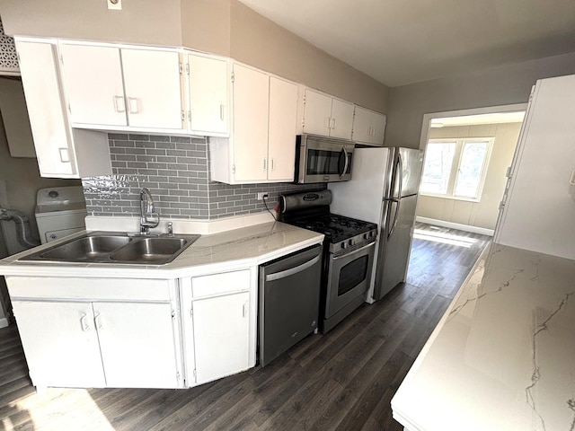 kitchen with stainless steel appliances, light countertops, white cabinetry, and a sink