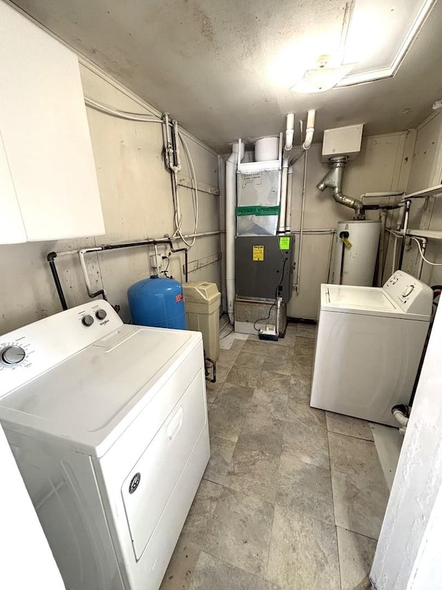 laundry room featuring washing machine and dryer, water heater, a textured ceiling, and heating unit