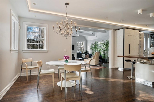 dining space featuring recessed lighting, a tray ceiling, baseboards, and dark wood-style floors