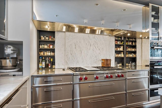 kitchen featuring open shelves, stainless steel counters, glass insert cabinets, and stainless steel gas cooktop