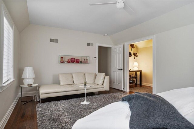 living room featuring visible vents, baseboards, lofted ceiling, and wood finished floors