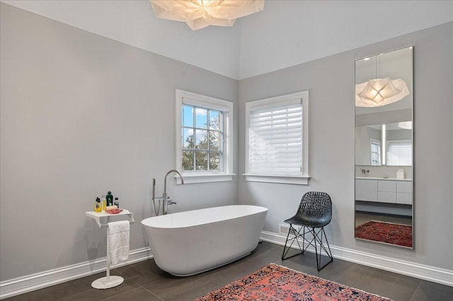 bathroom featuring baseboards and a soaking tub