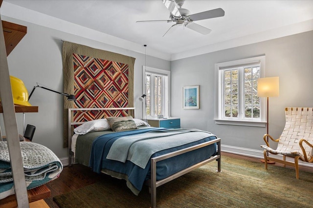 bedroom with ceiling fan, baseboards, and wood finished floors