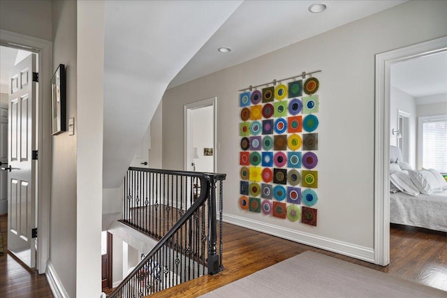 hall with recessed lighting, baseboards, an upstairs landing, and wood finished floors