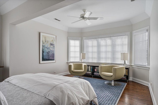 bedroom featuring a ceiling fan, wood finished floors, visible vents, and baseboards