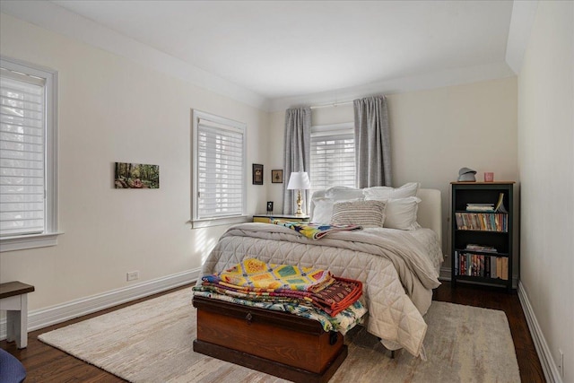 bedroom featuring baseboards and dark wood-style flooring